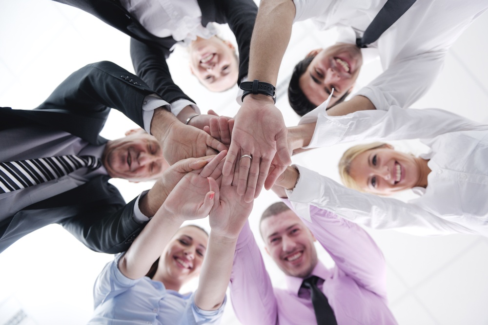 business people group joining hands and representing concept of friendship and teamwork,  low angle view