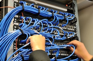 Man connecting network cables to switches-1