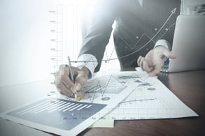 close up of businessman hand working on laptop computer with business graph information diagram on wooden desk as concept-2